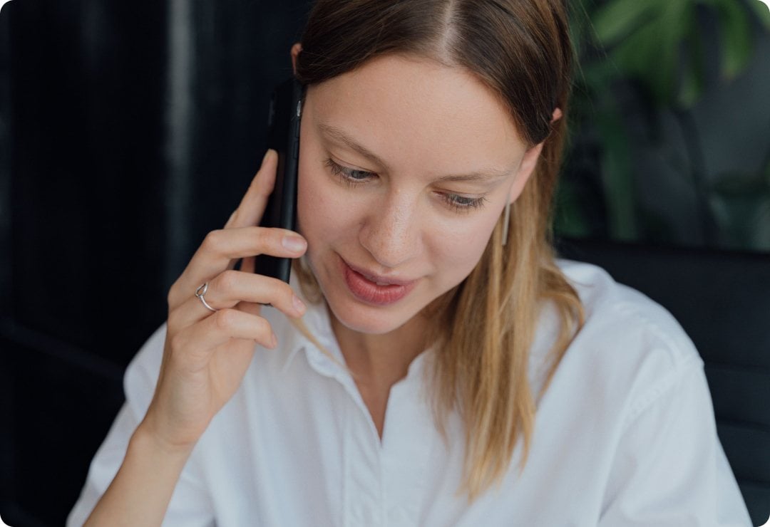 Woman on an inbound call at her desk, routed to the right place without a phone menu