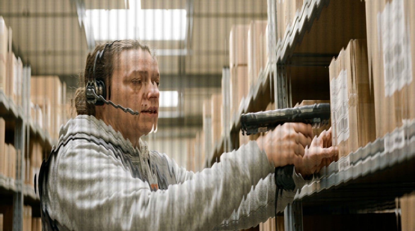 Warehouse picker on a headset call with a customer while scanning a shelf barcode